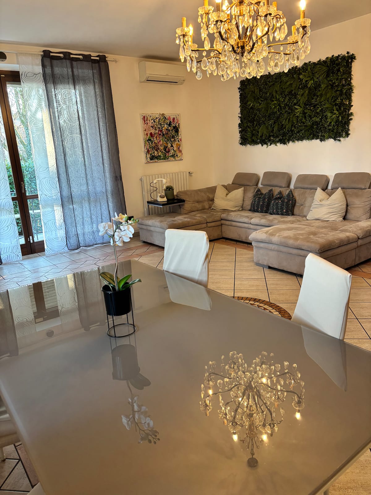 Soggiorno di Villa Enza con divano, tavolo in vetro e lampadario